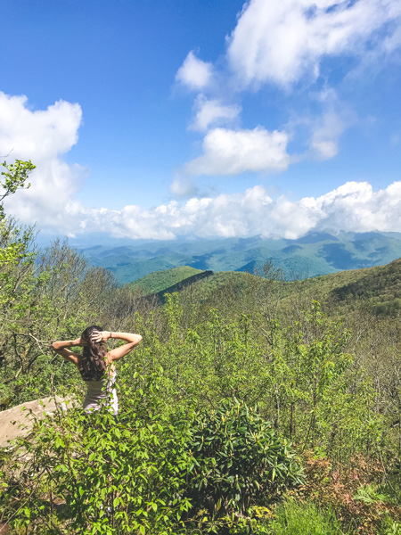 Craggy Gardens Blue Ridge Parkway with white brunette woman looking out over Blue Ridge Mountains