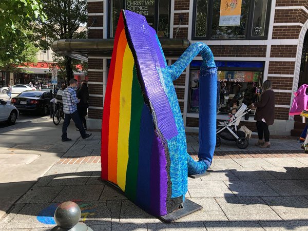 Large Flat Iron sculpture with temporary rainbow knitting over it in Downtown Asheville, NC