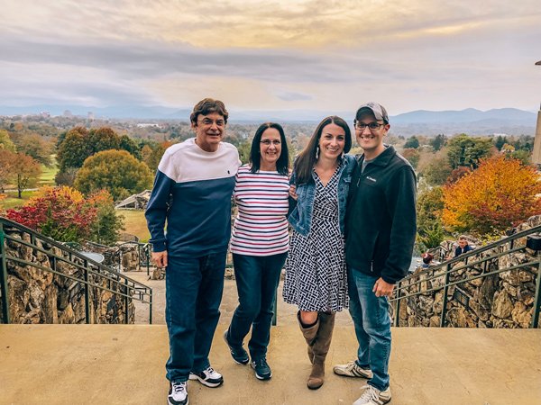 Omni Grover Park Inn Sunset with four people standing on Sunset terrance with sunset and fall foliage in background