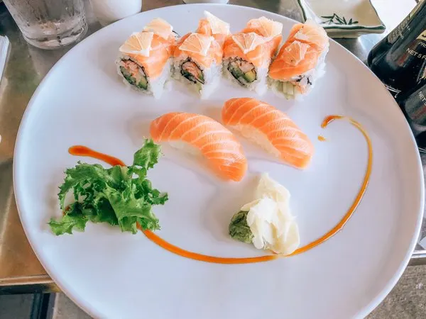 Zen Sushi Asheville NC with two salmon sashimi and sushi rolls on white plate with ginger and wasabi
