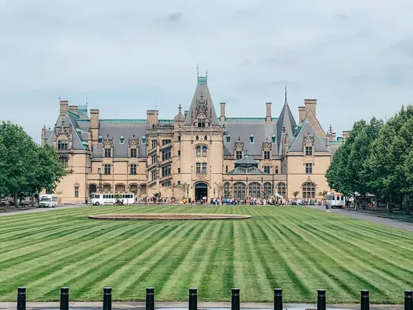 Biltmore Estate Asheville NC house with green grass and people and shuttles out front