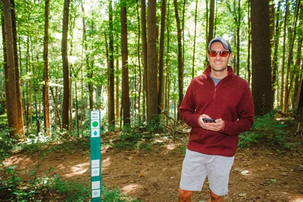 Free Things To Do At Biltmore Hiking Trails with white brunette male in front of hiking post