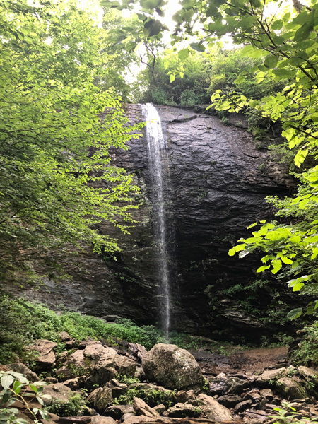 Douglas Falls Pisgah National Forest tall waterfall coming over a large rock onto smaller rocks