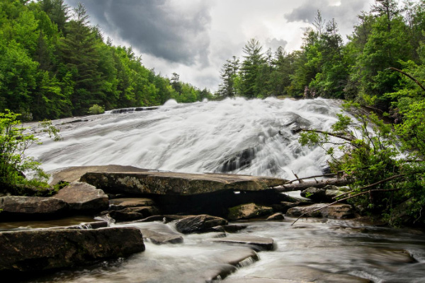 Bridal Veil Falls Waterfall Hike DuPont State Forest with picture of wide but short waterfall on brown rocks