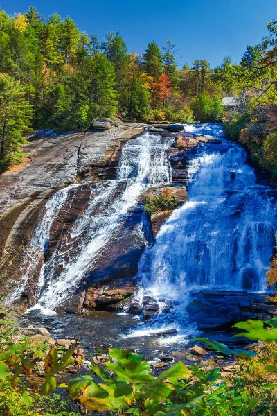 High Falls at DuPont State Forest waterfall in fall with colorful green, orange, and red trees
