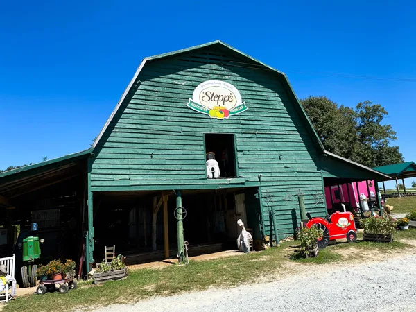 Stepp's Hillcrest Orchard Hendersonville NC green farm store with logo and red tractor out front
