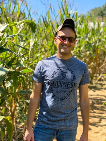 Stepp's Hillcrest Orchard Corn Maze with white male in blue shirt and sunglasses surrounded by tall corn stalks