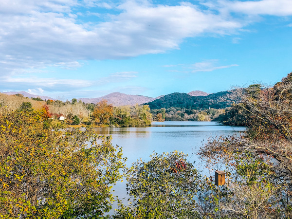 Parks In Asheville NC Beaver Lake with blue lake surrounded by Blue Ridge Mountains and fall foliage trees