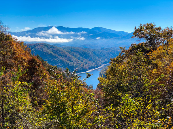 Fontana Lake Bryson City NC with fall foliage around a blue lake with mountains and clouds