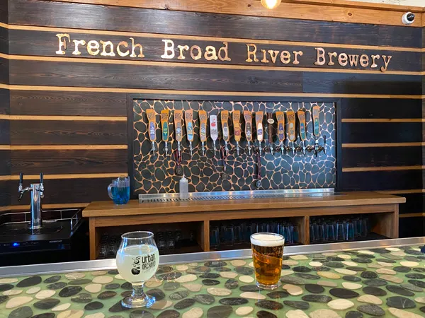French Broad River Brewery with taps and glass of cider and amber beer