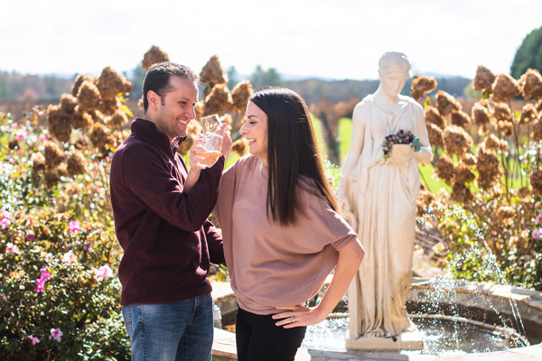 Hendersonville Wineries Burntshirt Vineyards with brunette white male and female drinking wine in front of a white statue and fountain