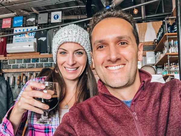 Hi Wire Brewing South Slope Asheville NC with brunette white male and female taking a selfie and holding beer