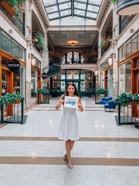 Historic Grove Arcade Asheville North Carolina with white brunette female holding a map of NC