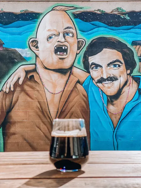 Lager at Burial Brewing Co Asheville with Sloth and Tom Selleck mural