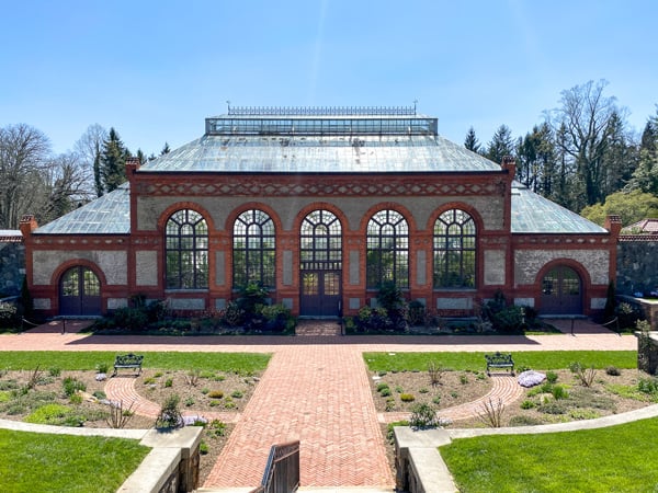 Biltmore Conservatory Asheville NC with large brick building with high windows at end of walled garden
