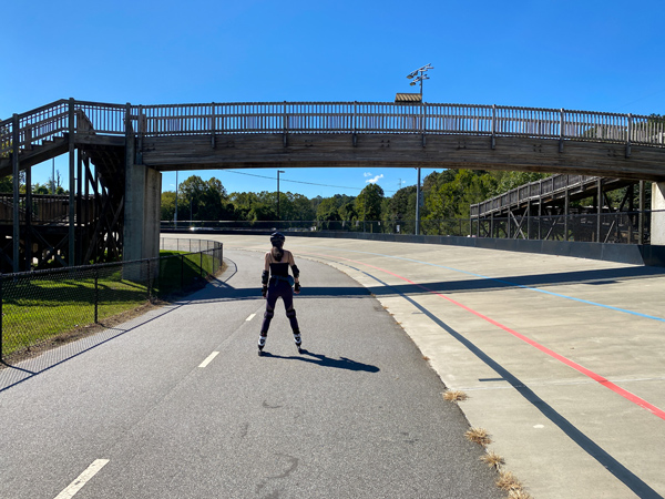 Mellowdrome Carrier Park Skating Asheville NC with female on roller blades on track going under a walking bridge