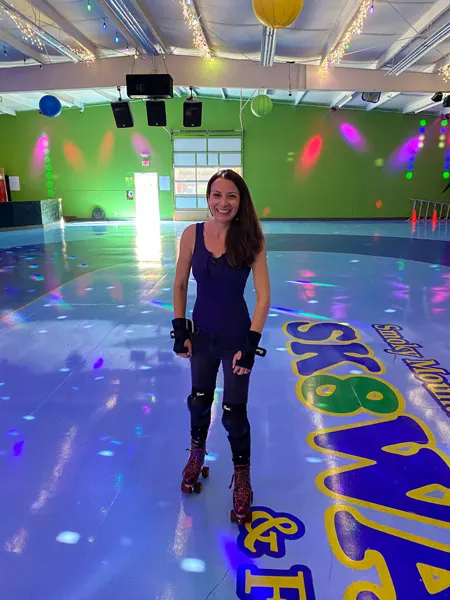 Smoky Mountain Sk8way Skating Waynesville NC with white brunette female on disco lights skating rink floor wearing garnet colored roller skates