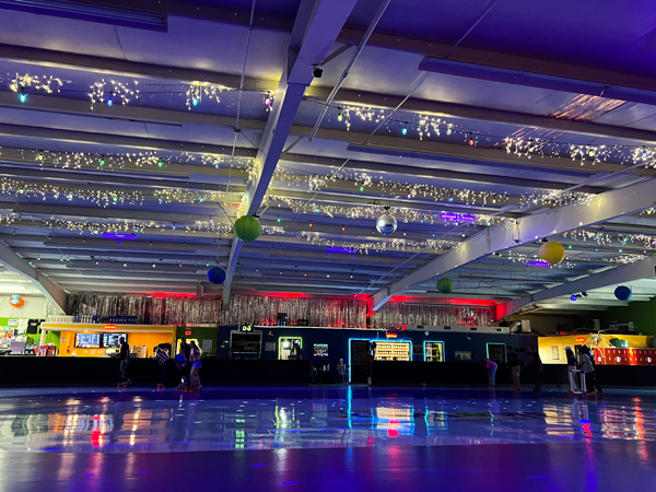 Smoky Mountain Sk8way Waynesville NC rink lit up with black lights, icicle ceiling lights, and red concession stands with purplish floor