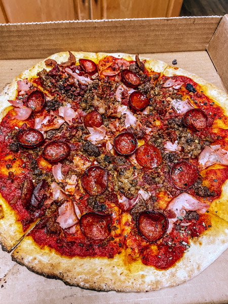 Asheville Brewing Pizza Delivery Takeout with meat lovers pizza with ham, pepperoni and red sauce