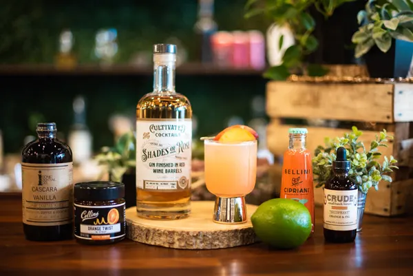 Asheville Distilleries Cultivated Cocktails with image of rum, cocktail, lime, syrups, bitters and more