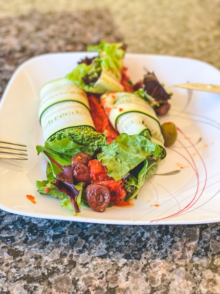 Asheville takeout Laughing Seed Cafe with vegan manicotti, lettuce, kalmata olives, and sun dried tomatoes