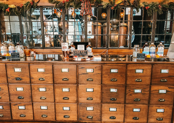 Chemist Spirits Distillery Asheville with wooden bar that looks like file holders and distillery in background