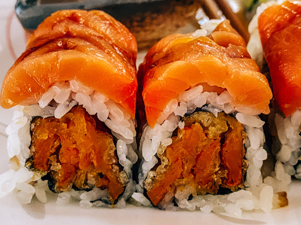 Hana Japanese Hibachi Sushi Bar Restaurant Asheville with sweet potato tempura sushi roll topped with smoked salmon and eel sauce