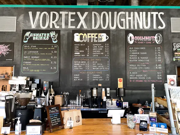 Vortex Doughnuts coffee donuts asheville menu, register, and bar for ordering all written in chalk on blackboard wall