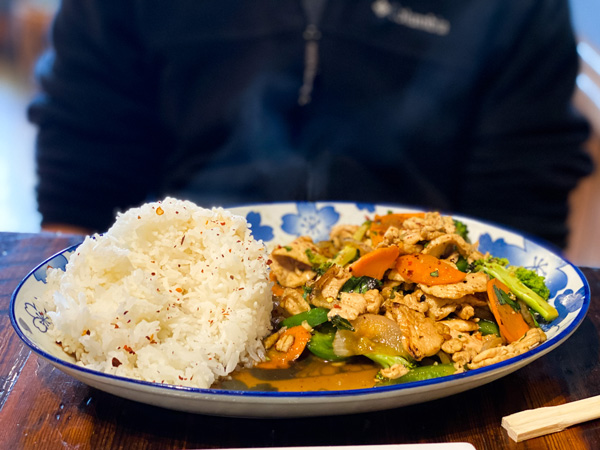 Best Thai Food Restaurants Asheville Thai Pearl with oval shaped plate filled with white rice and Thai basil dish with carrots and chicken