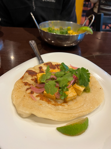 Blue Dream Curry House Indian Asheville NC with naan taco filled with tofu, purple cabbage, and cilantro with lime garnish