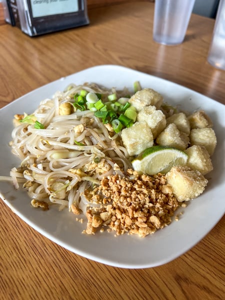 Boon Choo Flat Rock NC Pad Thai on white square dish on brown table with peanut, lime, and fried tofu on top