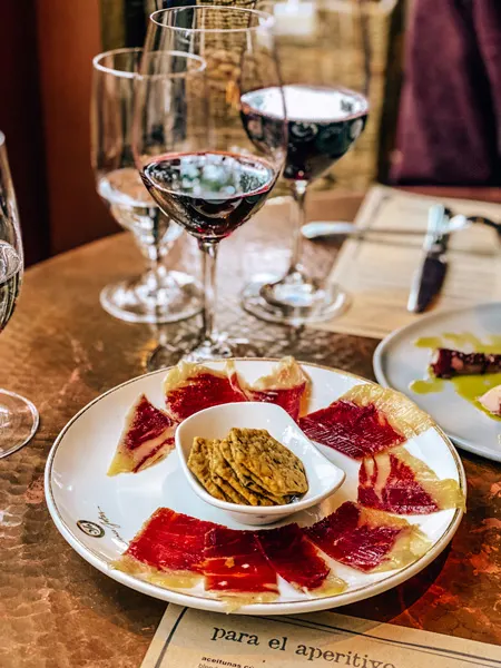 Jamon Charcuterie at Curate Asheville with two red wine glasses