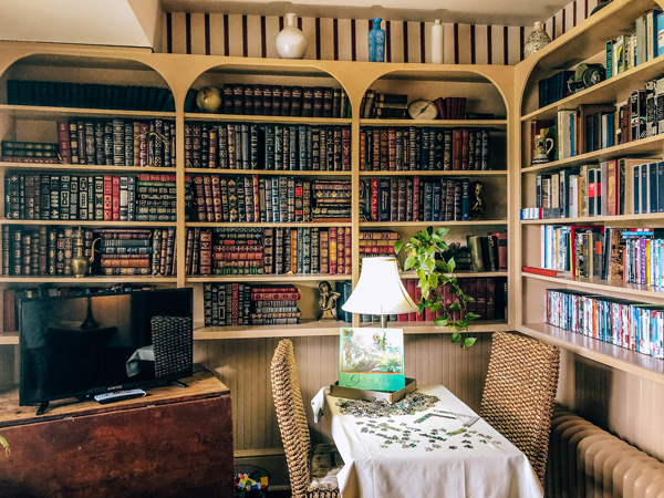 1898 Waverly Inn Bed and Breakfast Hendersonville NC living room with lamp, TV, and library filled with books