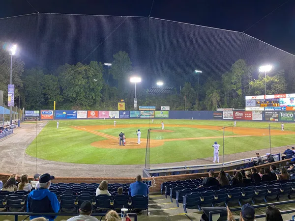 Asheville Tourists Baseball Game with baseball McCormick Field at night with players around the bases