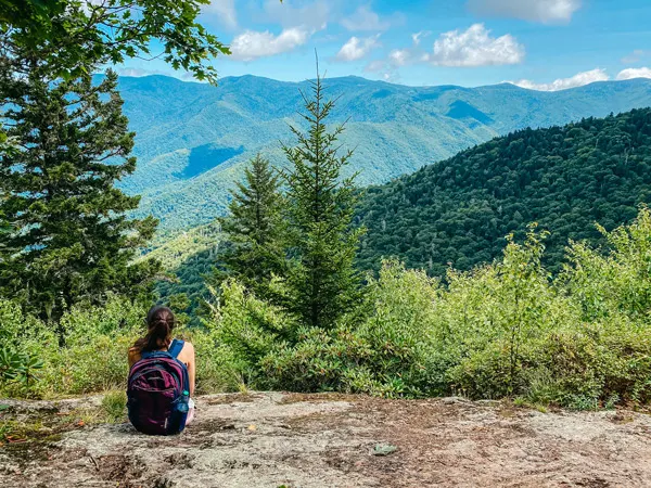 Picnics Blue Ridge Parkway Little Butt with white brunette woman sitting on a rock looking out at Black Mountain range