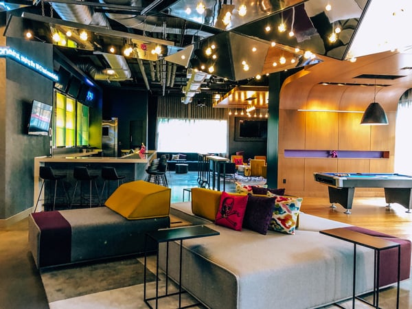 Aloft downtown Asheville Bar and Lounge with colorful pillows and gray couches