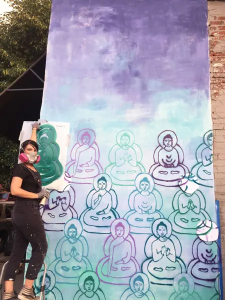 Asheville Murals Buddhas Downtown with artist Amanda Giacomini in front of purple, green and blue Buddhas