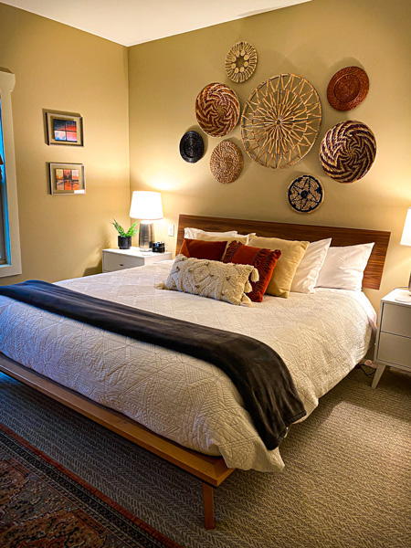 Bedroom Asheville Cottages with king size bed, beige walls, and red and tan pillows on white sheets