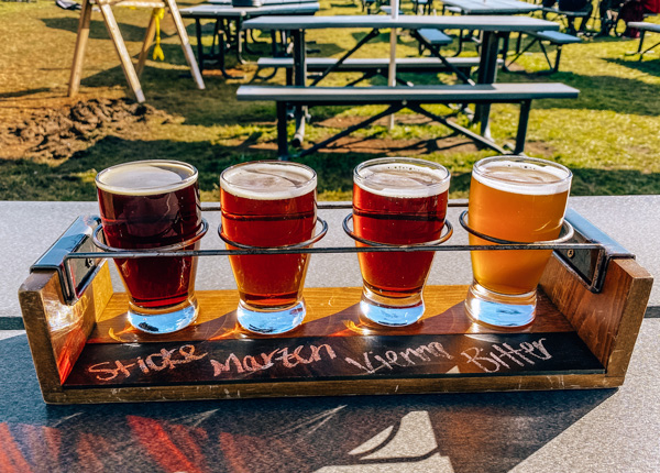 Burning Blush Brewery Near Brevard with flight of four amber to golden ales and picnic tables