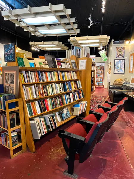 Downtown Books & News Used Bookstore Asheville with old red movie theater chairs in front of bookshelf filled with books