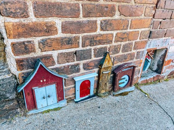 fairy houses Woodfin Street Asheville NC with small houses attached to brick wall