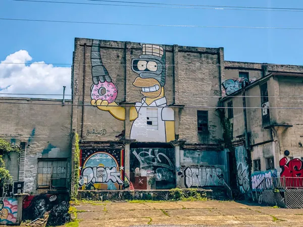Fender Bender Mural Asheville NC with Homer Simpson holding donut mixed with Bender from Futurama by Jerkface