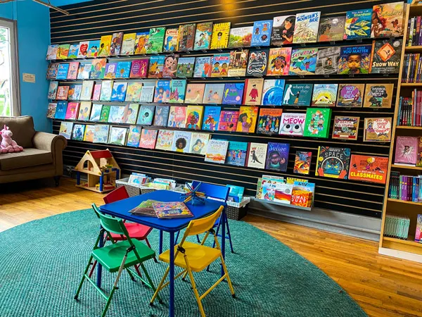 Firestorm Books & Coffee with children's section with colorful table and chairs and full book display along the wall