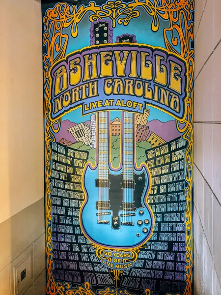 Live At Aloft Downtown Asheville Mural with blue guitar and names of music artists