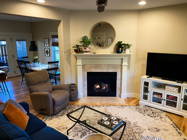 Living Room Asheville Cottages with fireplace, armchair, and blue couch with tan carpet