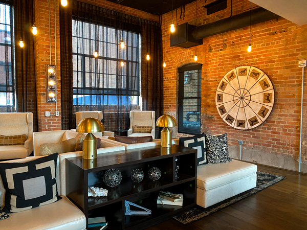 The Foundry Hotel Asheville NC Bar and Lounge with brick walls with circular decoration and off white chairs with black tables