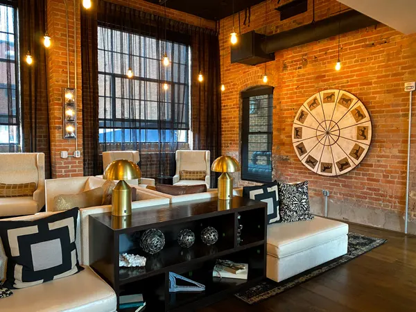 The Foundry Hotel Asheville NC Bar and Lounge with brick walls with circular decoration and off white chairs with black tables