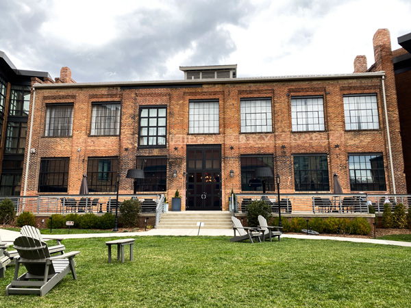 The Foundry Hotel Asheville NC facade with brick warehouse like building with large windows and green lawn