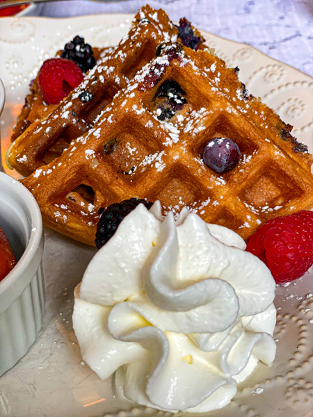 The Inn Around The Corner Black Mountain breakfast with waffles, blueberries, raspberries, and dollop of whip cream