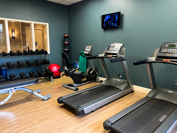 Village Hotel at Biltmore in Asheville NC gym with green walls, red exercise ball, two treadmills and weight bench